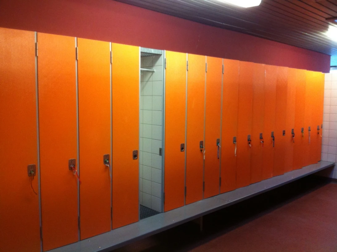 Schrank- und Umkleideanlage vor der Sanierung mit orangefarbenen Türen