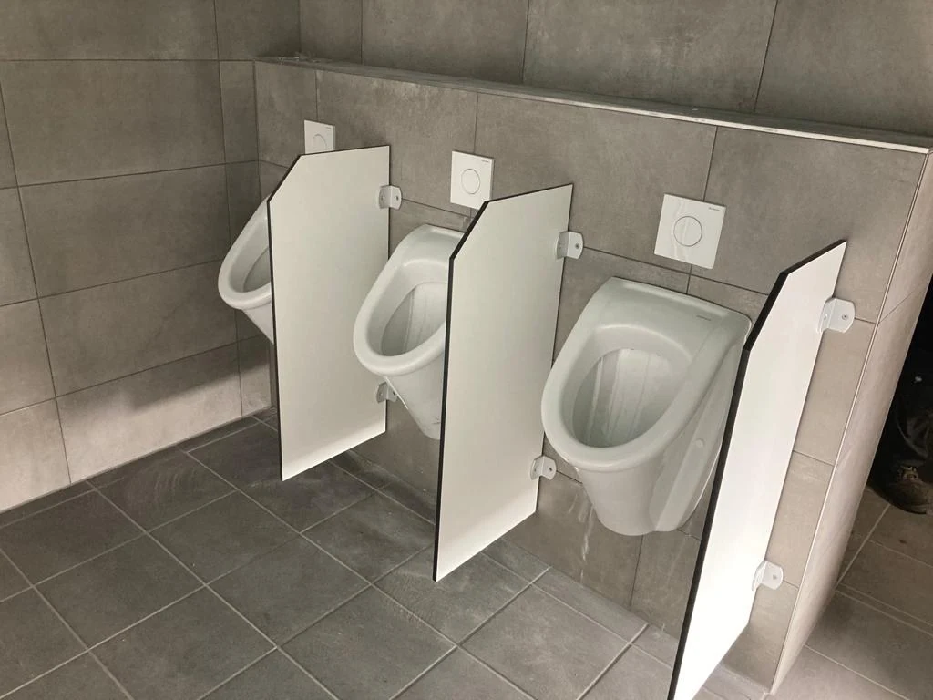 Weiße Urinaltrennwände der Serie N zwischen wandhängenden Urinalen